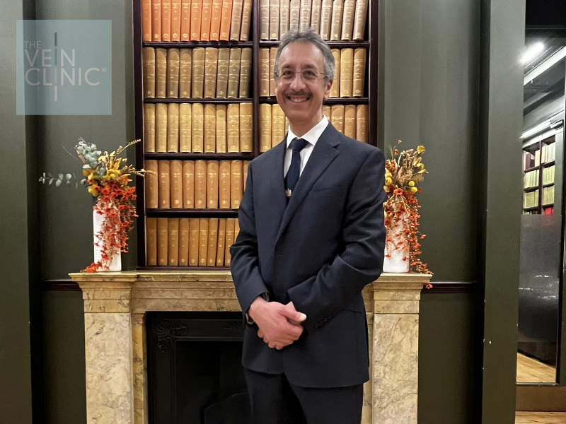 Ravi Singh-Ranger of The Vein Clinic, wearing a dark suit and college tie and standing in front of the library fireplace at The Royal College of Surgeons of England. Ravi Singh-Ranger of The Vein Clinic, wearing a dark suit and college tie and standing in front of the library fireplace at The Royal College of Surgeons of England.